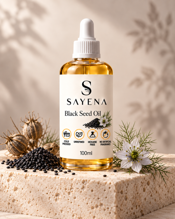 SAYENA Black Seed Oil 100ml bottle with nigella seeds on an ivory stone display