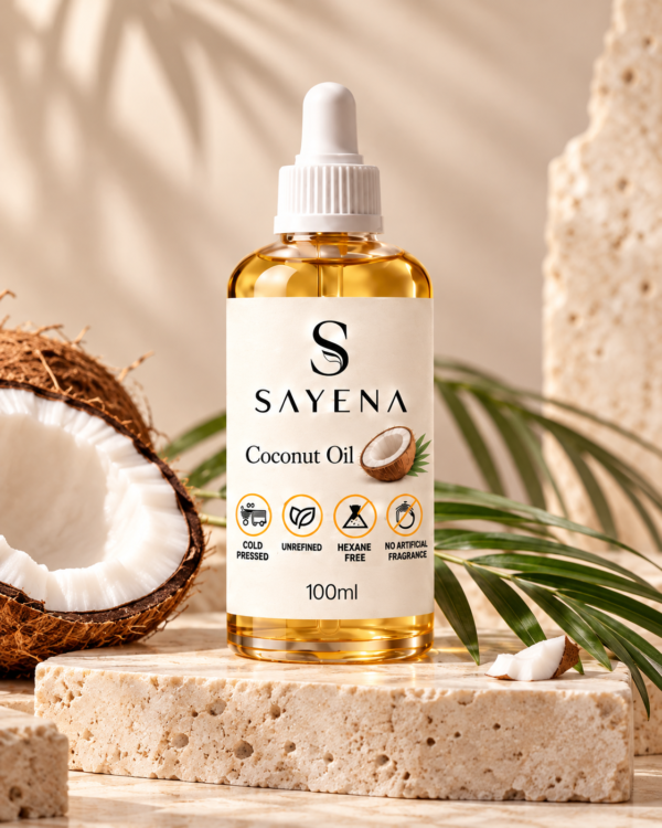 SAYENA Coconut Oil 100ml bottle with coconut on an ivory stone display