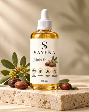 SAYENA Jojoba Oil 100ml bottle with botanical ingredients on an ivory stone display